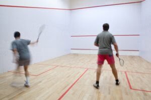 Squash Players In Action On A Squash Court (motion Blurred Image