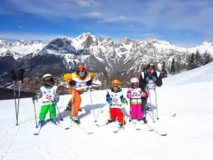Dzieci na nartach na tle gór We Włoszech.