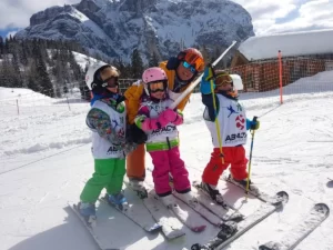 Dzieci na nartach na tle gór We Włoszech.