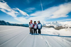Dzieci stojące na stoku narciarskim.